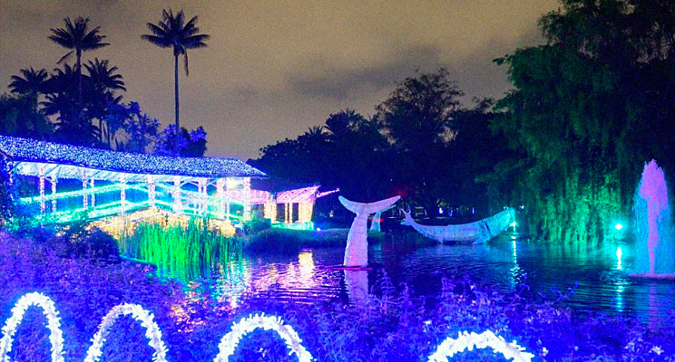 Foto del lago en el Jardín Botánico de Bogotá con el alumbrado navideño y esculturas de animales.