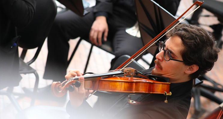 Fotografía a uno de los jóvenes violinistas en acción de la Filarmónica Juvenil