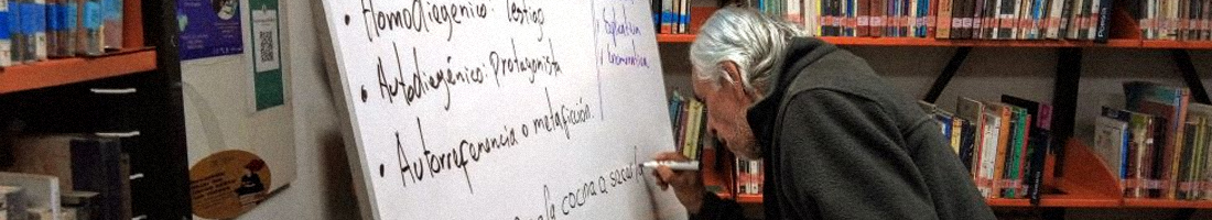 Señora de la tercera edad participando activa en el taller escribiendo sobre el tablero