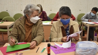 Dos mujeres adultas mayores charlando en el espacio de taller en la biblioteca