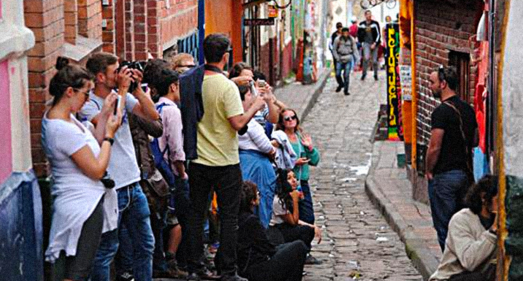 Fotografía de varios turista tomando fotos en el barrio la Candelaria de Bogotá
