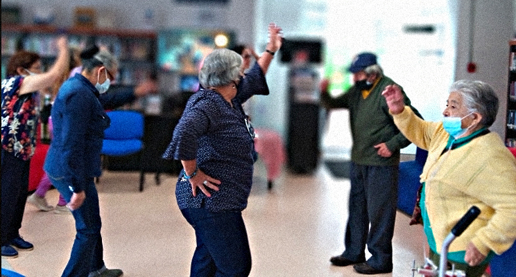 Personas de la tercera edad bailando en los talleres de la biblioteca