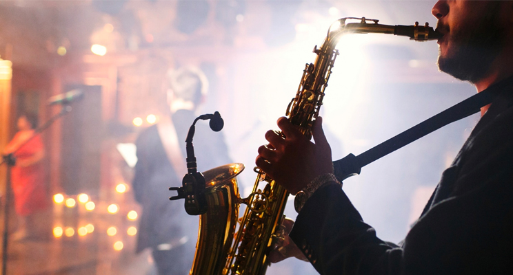 Foto en primer plano de un músico interprete de saxofón en acción.