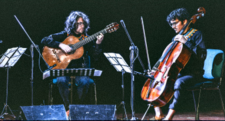 Fotografía de dos músicos de la Orquesta Filarmónica de Bogotá en concierto.