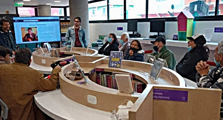 Fotografía de un grupo de adultos mayores en un espacio de taller en la biblioteca pública