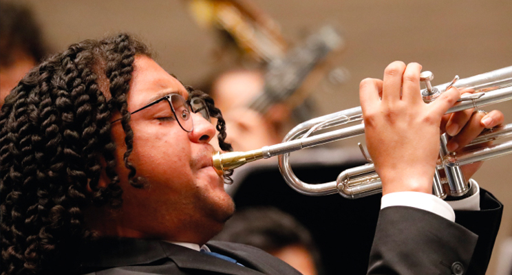 Foto detalle de un trompetista interpretando en vivo.