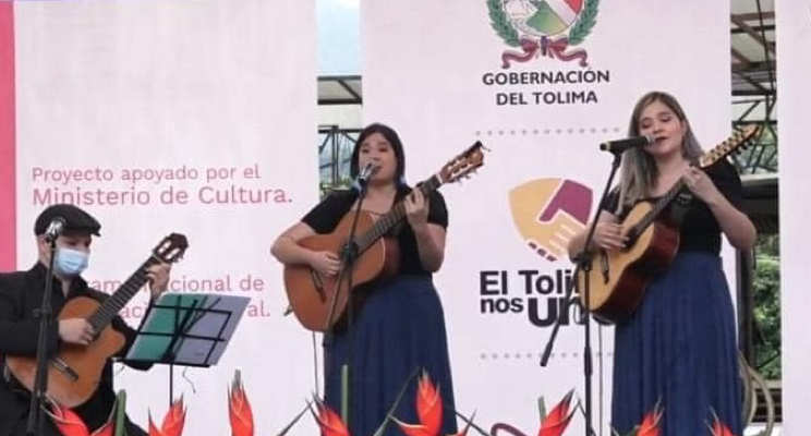 En la foto tres músicos dos mujeres un hombre interpretando un trío de música colombiana 