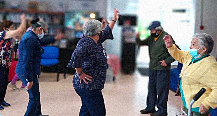 En la foto varias mujeres adultas mayores bailando y también un señor adulto mayor bailando.