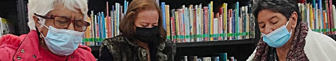 Señoras de la tercera edad leyendo concentradas en la biblioteca