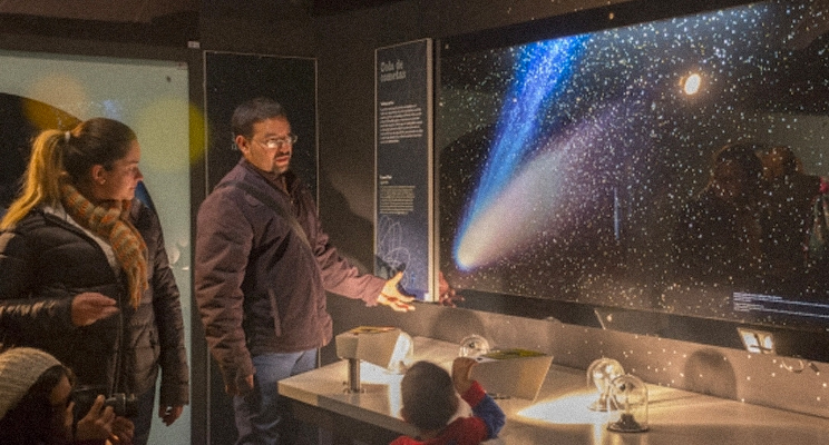 Un mujer y un hombre mirando el universo sobre una pantalla en el Planetario de Bogotá