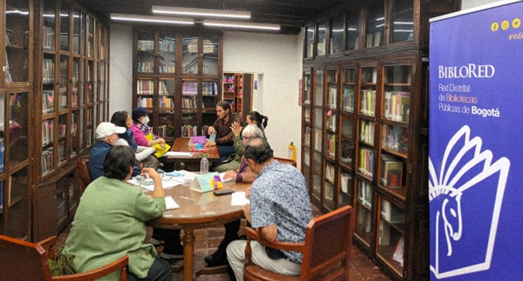 Adultos mayores en el espacio de la biblioteca tomando un taller