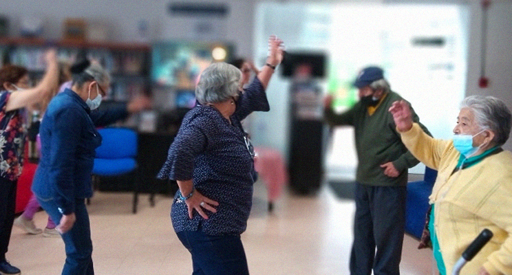 Adultos mayores en actividad física en el espacio de taller en la biblioteca