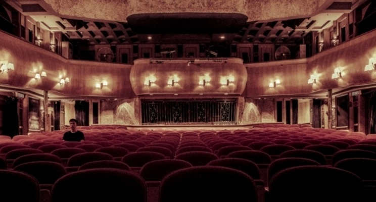 En la foto se ve un teatro vacio con solo una persona en el público