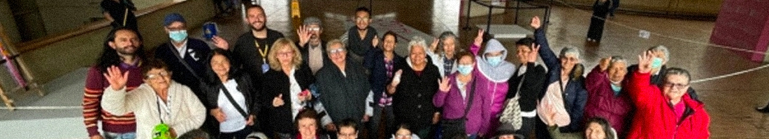 Grupo de personas adultas mayores con jóvenes en la biblioteca posando para la foto y sonriendo