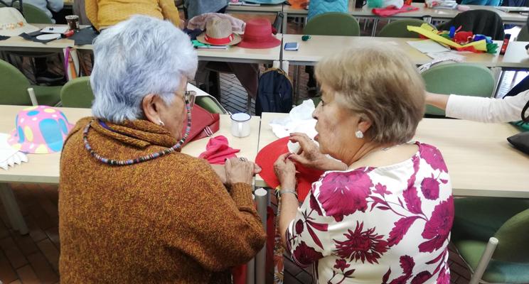 Dos adultas mayores conversando y participando del espacio de taller