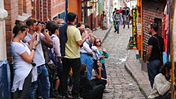 Fotografía de varios turista tomando fotos en el barrio la Candelaria de Bogotá