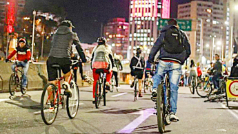 Grupo de personas en la ciclovía nocturna por la calle 26 en Bogotá