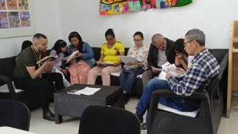 Grupo de personas de diferentes edades leyendo en el espacio de la biblioteca