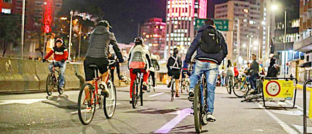 Grupo de personas en la ciclovía nocturna por la calle 26 en Bogotá